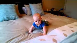 Liam crawling backwards and drooling on our bed.