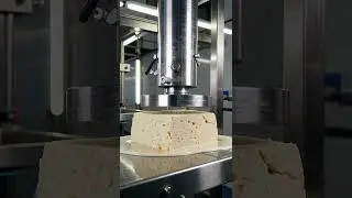 Block of paneer slowly crushed under powerful hydraulic press.