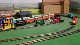 Bachmann Rheneas pulling 4 brown 3 grey slate wagons, blue box van and red brakvan 