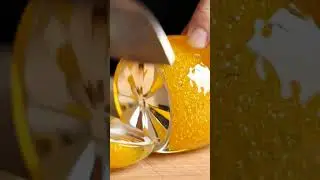 glass sculpture of a (lemon) on a wooden cutting board viral video