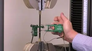 Transverse extensometer installation on a composite specimen to measure Poisson&rsquo;s ratio (Model 3575)