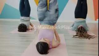 Attractive slender women doing yoga in studio laying on mats with legs up wearing sportswear