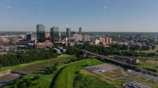 Fort Worth, Texas skyline with green riverbanks and city buildings across Trinity River from an