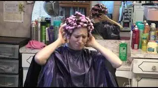Woman pouting and mad with perm rods in her hair at the salon