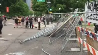 RAW: Protesters build barricade from chain link fence and road closure sign in Denver