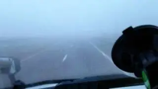 Semi truck driving through fog