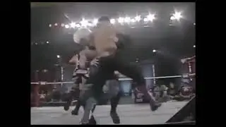 Tony Mamaluke swinging ddt on Ace Steel through table