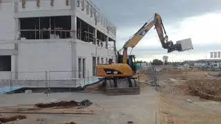 Cat 315 D rototilt z widłami podaje palety na strop.