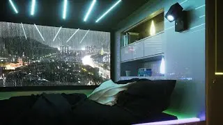 Capsule hotel bedroom with town night view | rain on window