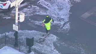 Crossing guard carries child across flooded Chicago street