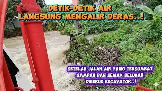 Detik-detik air mengalir deras setelah jalan air yang tertutup semak belukar dikeruk excavator 