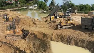 Specializing Machine on construction Land filling up In Deep Pond Two Dozer Pushing Soil Into Water
